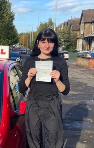 Kasha holding their practical driving test pass certificate after passing with MK Driving School in East London, October 2023