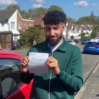 Monirul holding their practical driving test pass certificate after passing with MK Driving School in East London, April 2026
